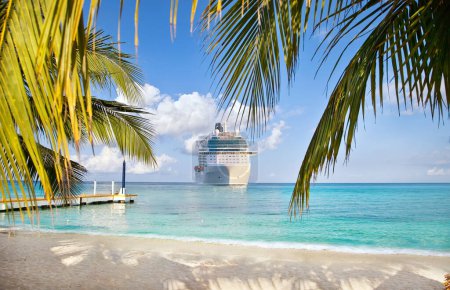 Téléchargez les photos : Vue de la plage tropicale sur le bateau de croisière naviguant vers le port - en image libre de droit