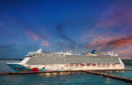 Téléchargez les photos : Costa Maya, Mexique - 5 avril 2019 : Le navire Norwegian Cruise Line Norwegian Breakaway accoste au coucher du soleil dans le port de Costa Maya. Le bateau de croisière peut accueillir plus de 4000 passagers et 1600 membres d'équipage. - en image libre de droit