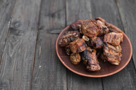 Foto de Deliciosas costillas de cerdo a la parrilla kebab. carne rústica en un plato sobre una mesa de madera. - Imagen libre de derechos