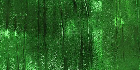 El desenfoque es un fondo verde texturizado abstracto. vidrio húmedo