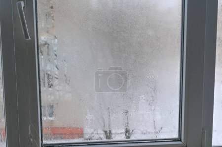 La condensación cae en la ventana. Un fragmento de vidrio mojado de una ventana de plástico.