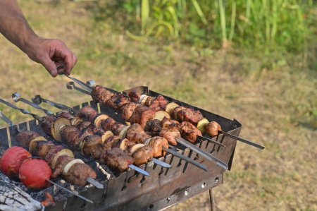 meat with mushrooms is cooked on skewers on the grill.