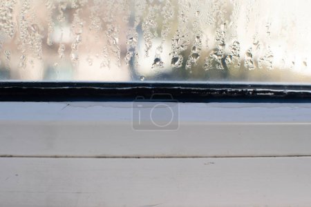 le verre mouillé de la fenêtre en plastique. augmentation de l'humidité.