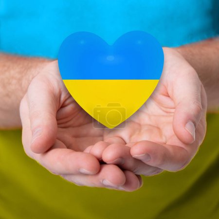 Téléchargez les photos : Mades de coeur de couleurs jaunes et bleues du drapeau national de l'Ukraine dans les mains des hommes. Arrêtez la guerre! - en image libre de droit