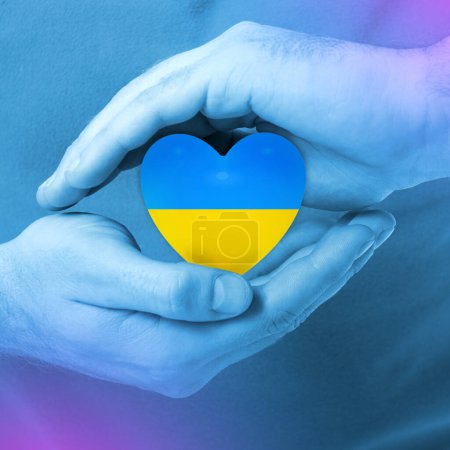 Téléchargez les photos : Les mains masculines prennent soin des mades d'icône de coeur de couleurs jaunes et bleues du drapeau national de l'Ukraine, image tonique - en image libre de droit