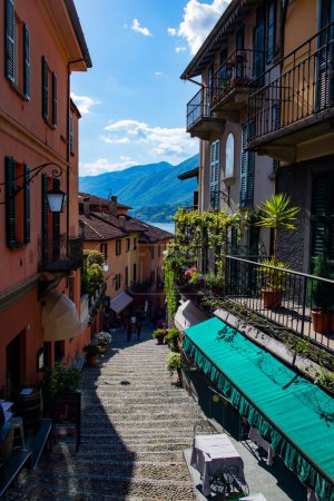 Photo for Italian town Bellagio. Narrow old street with beautiful houses and stairs leading down to Lake Como overlooking the Alps - Royalty Free Image