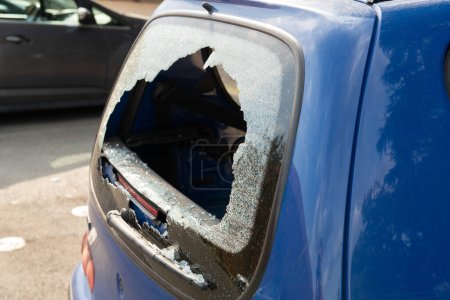 Photo for Rear window shattered in car parked in street parking. Thieves broke the glass in the automobile - Royalty Free Image