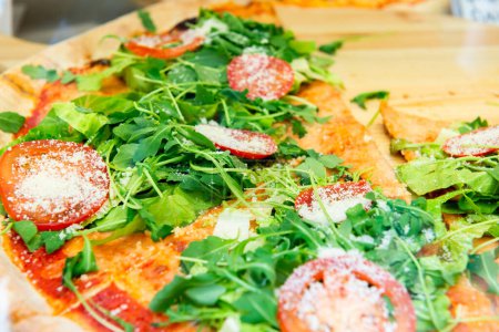 Photo for Pizza with tomatoes, cheese and arugula solds in a street food cafe in Italy - Royalty Free Image