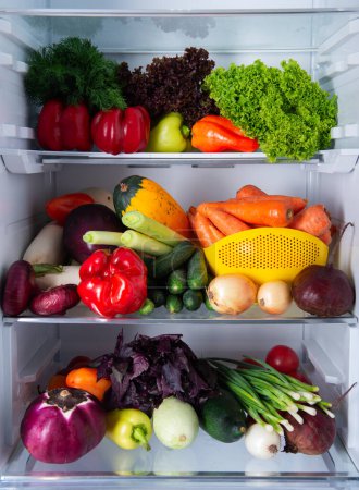 Photo for Open refrigerator full of fresh ripe seasonal vegetables. The concept of diet, healthy eating and vegetarianism - Royalty Free Image