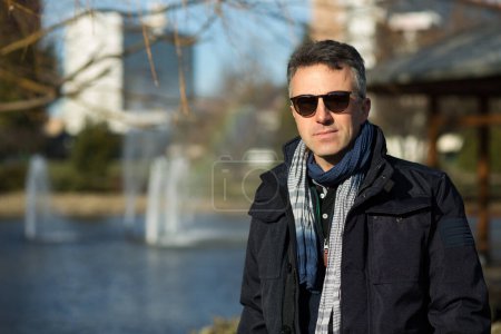 Téléchargez les photos : Un bel homme mûr. Portrait masculin d'hiver extérieur. attrayant confiant homme d'âge moyen en lunettes de soleil. - en image libre de droit