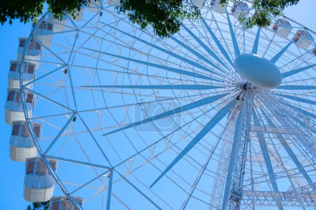 Téléchargez les photos : Grande roue dans le parc d'attractions sur ciel bleu - en image libre de droit