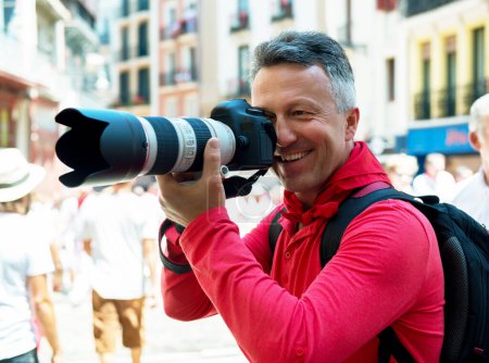 Téléchargez les photos : Photographe à San Fermin. Photojournaliste. Les gens célèbrent le festival San Fermin dans des vêtements blancs et rouges traditionnels avec cravate rouge, Pampelune, Navarre, Espagne. - en image libre de droit