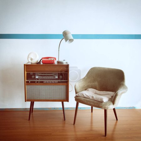Téléchargez les photos : Chambre vintage avec fauteuil à l'ancienne, plaque tournante radio rétro, téléphone et lampe standart. Intérieur du XXe siècle, nostalgie - en image libre de droit