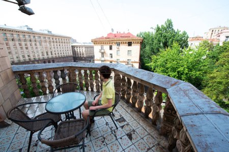 Téléchargez les photos : Adolescent s'assoit et se détend et profite de la vue sur Kiev et la rue principale Khreshchatyk. Ukraine - en image libre de droit