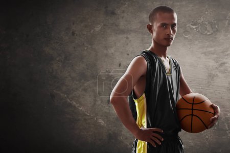 Photo for Asian male basketball player holding a ball - Royalty Free Image