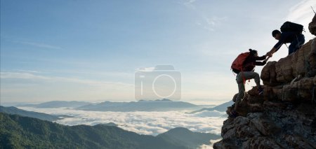 Foto de Senderismo asiático ayudarse mutuamente en vistas a las montañas. concepto de trabajo en equipo - Imagen libre de derechos