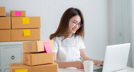 Téléchargez les photos : Jeune fille asiatique est pigiste avec son entreprise privée au bureau à la maison. Concept de travail à domicile - en image libre de droit