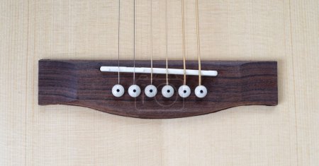 Foto de Musical instrument - Closeup top view bridge acoustic guitar, pins and strings. - Imagen libre de derechos