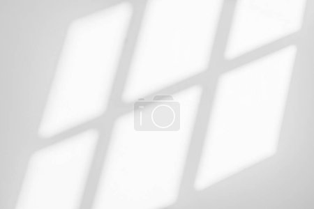 Abstrakte Lichtreflexion und grauer Schatten aus dem Fenster auf weißem Wandhintergrund, dunkelgraue Schatten und Sonnenscheineffekt für Hintergrund und Attrappe