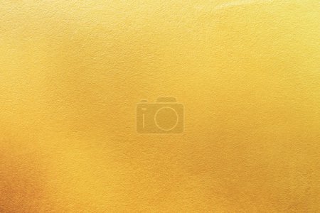 Gold Wand Textur Hintergrund. Gelb glänzende goldene Folienfarbe auf Wandoberfläche mit Lichtreflexion, lebendige goldene Luxus-Tapete