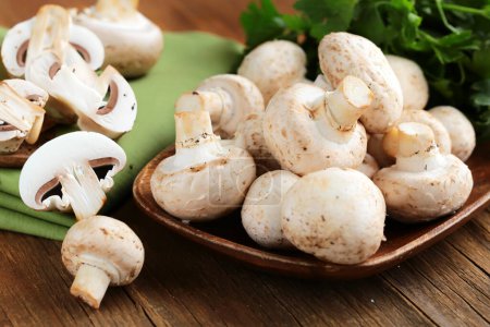 Photo for Fresh champignon mushrooms on a wooden board - Royalty Free Image