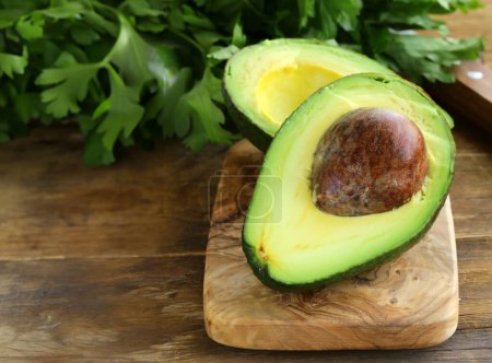 Photo for Fresh avocado for salad on a wooden table - Royalty Free Image