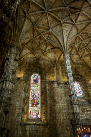Foto de Detail portrait view of a stained glass window and a gothic column inside the Jeronimos convent church in Lisbon, Portugal - Imagen libre de derechos