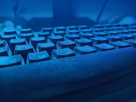 Téléchargez les photos : Détail du clavier en faible luminosité dans les tons de bleu, gros plan - en image libre de droit