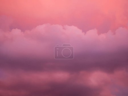 Detail rötlicher und violetter Wolken am Abendhimmel, ein seltenes atmosphärisches Phänomen der Beleuchtung von Wolken durch die Sonne bei Sonnenuntergang, Wolkenlandschaft als Muster