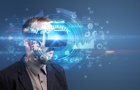 Foto de Hombre de negocios mirando a través de gafas de Realidad Virtual con inscripción FUTURÍSTICA, concepto de tecnología innovadora - Imagen libre de derechos