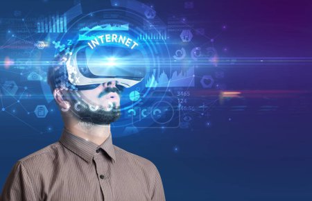 Foto de Hombre de negocios mirando a través de gafas de realidad virtual con inscripción INTERNET, concepto de tecnología innovadora - Imagen libre de derechos