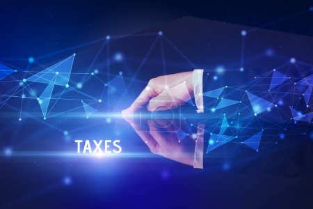 Businessman touching huge screen with TAXES inscription, modern technology business concept