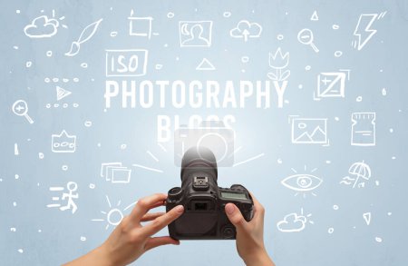 Foto de Fotografía a mano con cámara digital e inscripción FOTOGRAFÍA BLOGS, concepto de ajustes de cámara - Imagen libre de derechos
