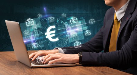 Photo for Business hand working in stock market with euro icons coming out from laptop screen - Royalty Free Image