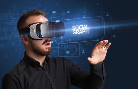 Foto de Hombre de negocios mirando a través de gafas de realidad virtual con inscripción SOCIAL GRAPH, concepto de redes sociales - Imagen libre de derechos