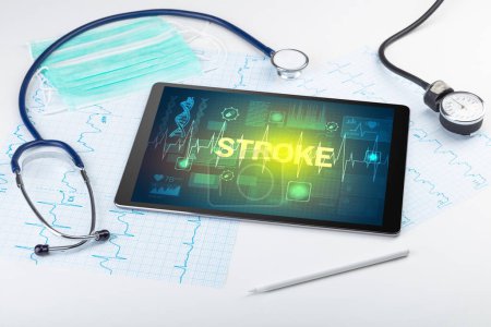 Téléchargez les photos : Tablette PC et matériel médical avec inscription STROKE, concept de prévention - en image libre de droit