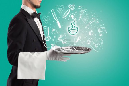 Foto de Camarero sosteniendo bandeja de plata con iconos de sopa saliendo de ella, concepto de comida saludable - Imagen libre de derechos