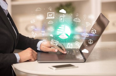 Téléchargez les photos : Homme d'affaires travaillant sur un ordinateur portable avec des icônes de diagramme à secteurs qui en ressortent, concept d'entreprise en pleine croissance - en image libre de droit