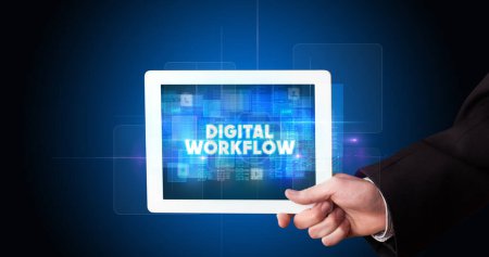 Photo for Young business person working on tablet and shows the inscription: DIGITAL WORKFLOW - Royalty Free Image