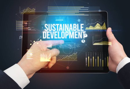 Photo for Close-up of hands holding tablet with SUSTAINABLE DEVELOPMENT inscription, modern business concept - Royalty Free Image
