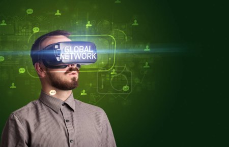 Téléchargez les photos : Homme d'affaires regardant à travers des lunettes de réalité virtuelle avec inscription GLOBAL NETWORK, concept de réseau social - en image libre de droit