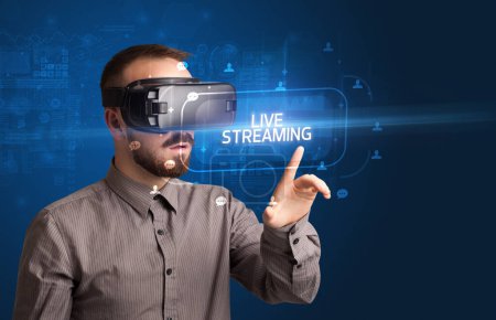 Téléchargez les photos : Homme d'affaires regardant à travers des lunettes de réalité virtuelle avec inscription LIVE STREAMING, concept de réseautage social - en image libre de droit