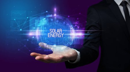 Téléchargez les photos : Homme main tenant SOLAR ENERGY inscription, concept technologique - en image libre de droit