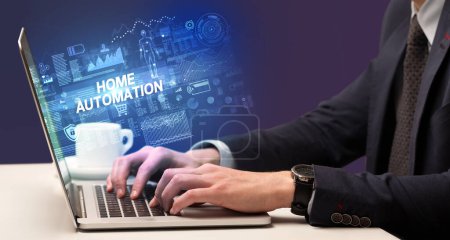 Téléchargez les photos : Homme d'affaires travaillant sur ordinateur portable avec HOME AUTOMATION inscription, concept de cybertechnologie - en image libre de droit
