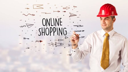 Photo for Handsome businessman with helmet drawing ONLINE SHOPPING inscription, contruction sale concept - Royalty Free Image