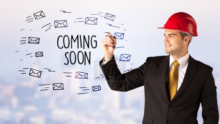 Photo for Handsome businessman with helmet drawing COMING SOON inscription, contruction sale concept - Royalty Free Image