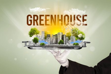 Foto de Camarero sirviendo eco ciudad con inscripción GREENHOUSE, concepto de energía renovable - Imagen libre de derechos
