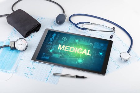 Téléchargez les photos : Tablette pc et matériel médical avec inscription MEDICAL, concept de prévention - en image libre de droit