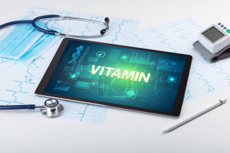 Foto de Tablet PC y material médico con inscripción VITAMIN, concepto de prevención - Imagen libre de derechos