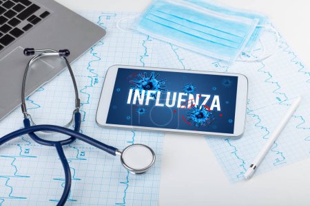 Photo for Tablet pc and doctor tools on white surface with INFLUENZA inscription, pandemic concept - Royalty Free Image